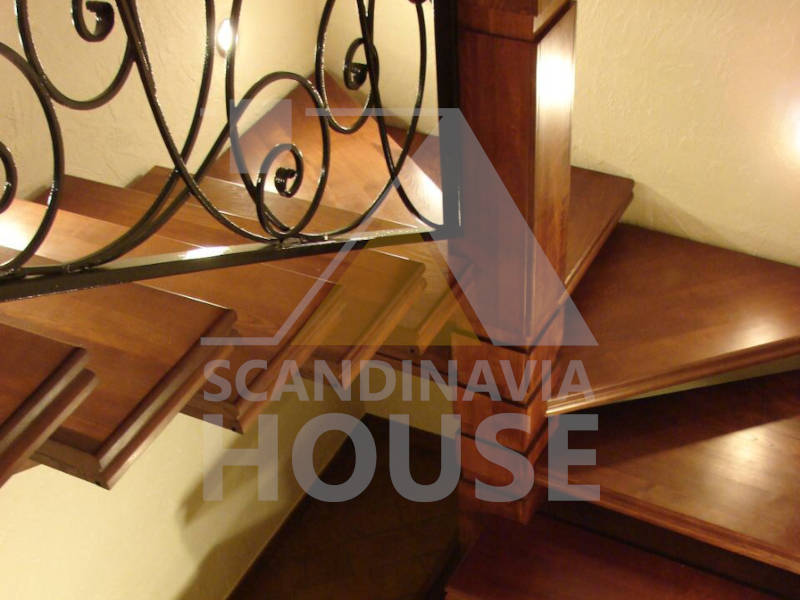 Лестница на металлокаркасе с деревянными ступенями и кованным ограждением
